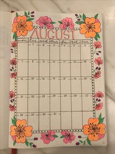 a calendar with flowers on it and the word august written in cursive writing