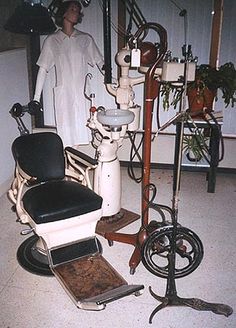 an old fashioned barber chair sitting in front of a hair dryer and other tools