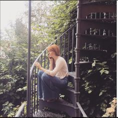 a woman sitting on top of a set of stairs