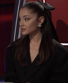 a woman sitting in front of a laptop computer on top of a red and black chair