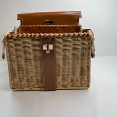 a brown wicker purse sitting on top of a white table