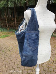 a white mannequin holding a blue jean purse