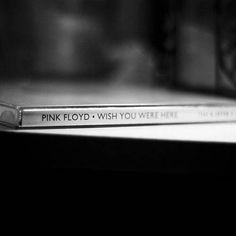 the pink floyd wish you were here book is sitting on top of a shelf next to a camera