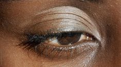 Closeup black woman with brown eye and curly eyelashes looking at camera at daytime. Dull Eyes, Curly Eyelashes, Brown Eye Photography, Black Person Eyes Aesthetic, Brown Eye Close Up, Brown Eyes In The Sun, Downturned Eyes, Feline Eyes Black Women, Eyes Looking Down