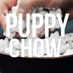 a bowl filled with white puppy chow next to a hand holding a spoon in it