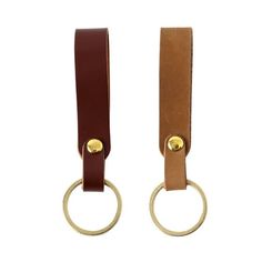 two brown and tan leather keychains with gold rings on each side, one has a ring at the end