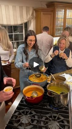 a group of people standing in a kitchen preparing food on top of a stovetop