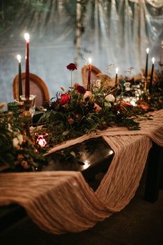 the table is set with candles and flowers on it, along with other items for decoration