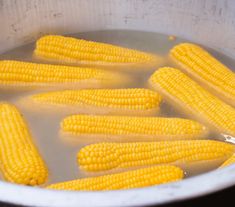 corn is being cooked in a pot with water