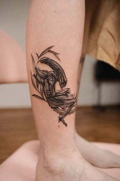 a tattoo on the leg of a person with a lizard crawling through it's legs