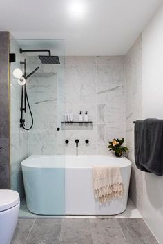 a white bath tub sitting next to a toilet