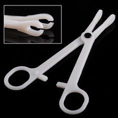 pair of white plastic scissors on black background