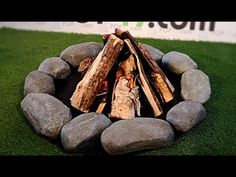 a fire pit made out of logs and rocks on grass with the words topgol com written above it