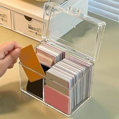 a person holding a card in a clear case on top of a table with other cards