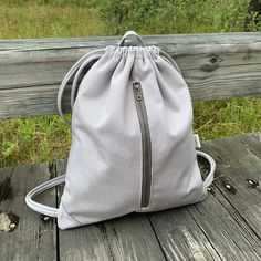 a gray bag sitting on top of a wooden bench