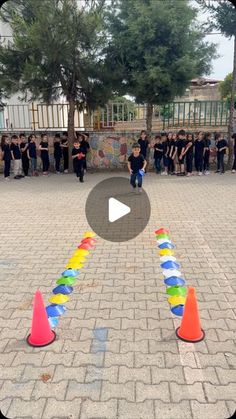 a group of people standing around colorful cones