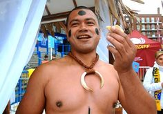 a man with his face painted like a crescent and holding a hot dog in front of him