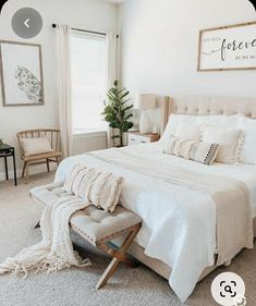 a bedroom with white bedding and pillows