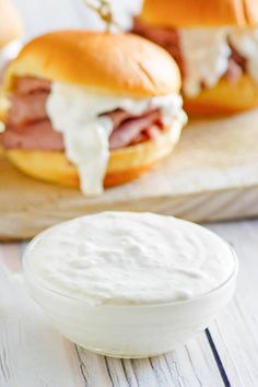 ham and cheese sandwiches with ranch dressing on a cutting board