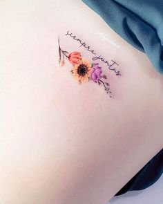 a woman's lower back tattoo with flowers and the words, you are my sunshine