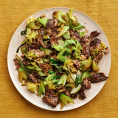 a white plate topped with beef and broccoli