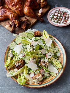 a salad with lettuce and radishes on a plate next to chicken