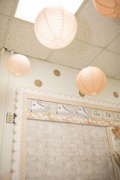 some paper lanterns hanging from the ceiling in a room with white walls and polka dots