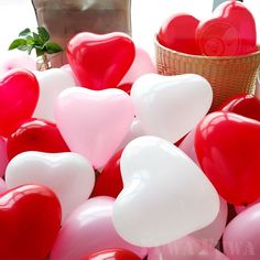 a basket filled with lots of red and white heart balloons