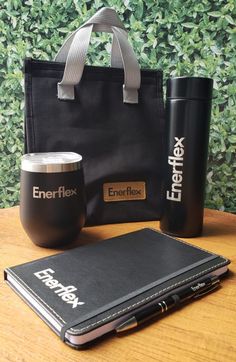 an energy flex bag, coffee cup and notebook on a wooden table next to a green wall