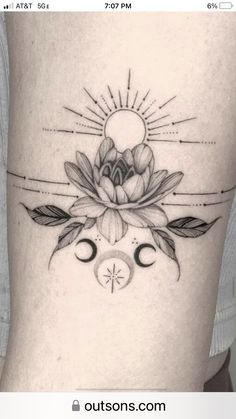 a black and white photo of a woman's thigh with flowers on it, the sun