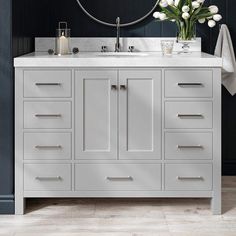 a bathroom vanity with two sinks and a mirror on the wall next to it is decorated with white tulips