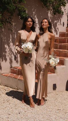 two women standing next to each other holding bouquets