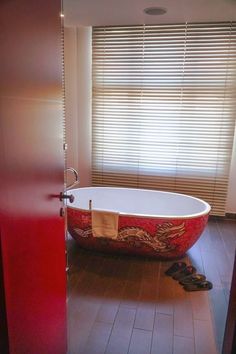 a bathroom with a claw foot bathtub in the middle and a pair of shoes on the floor