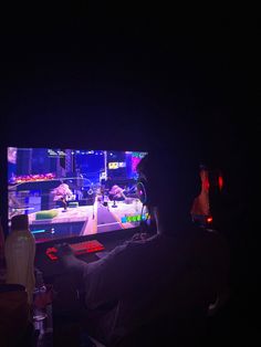 two people playing a video game in the dark