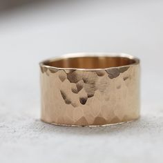 a close up of a gold ring on a white surface with no one around it