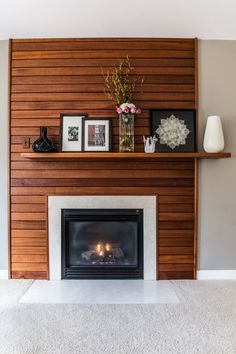 a living room with a fireplace and pictures on the mantle