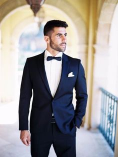 a man in a tuxedo is posing for the camera