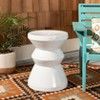 a white toilet sitting on top of a rug next to a chair and potted plant