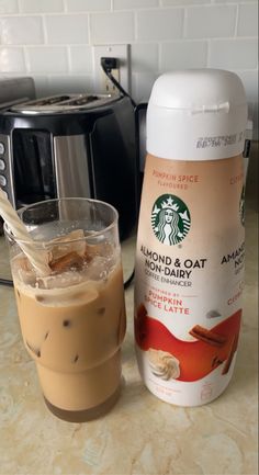 there is a cup of coffee next to a blender and a canister on the counter