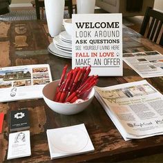 there is a bowl full of red crayons on the table next to newspapers