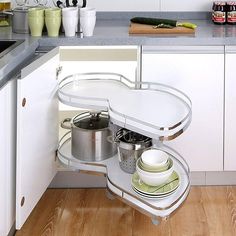 an open kitchen cabinet with pots and pans on the bottom shelf in front of it