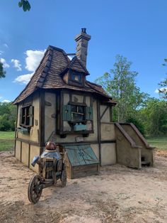 an old fashioned motorcycle parked in front of a small house with a chimney on the roof