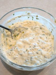 a glass bowl filled with cheese sauce on top of a table