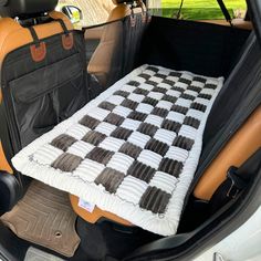 an open car trunk with a checkered blanket on it