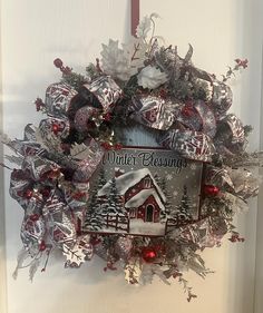 a christmas wreath hanging on the front door with a winter blessing sign attached to it