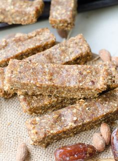 some kind of granola bar sitting on top of a table next to nuts and raisins