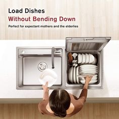 a woman is looking down at the dishes in the kitchen sink that she has taken out