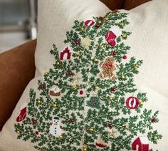 a decorative christmas tree pillow on a couch