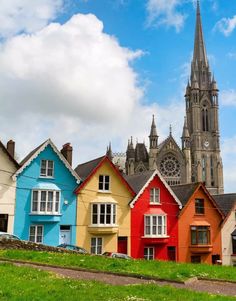 a row of colorful houses with a church in the background