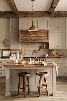 a kitchen with two stools in front of an island and wooden beams on the ceiling